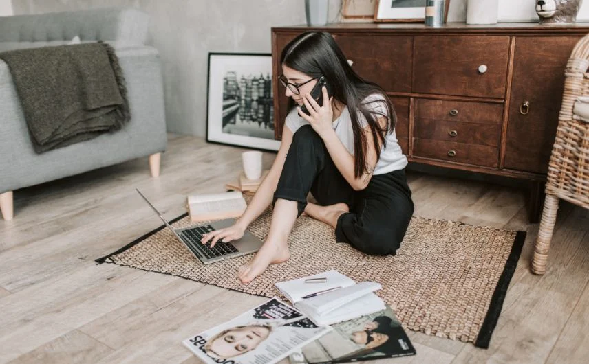 chica trabajando en el suelo, con revistas alrededor