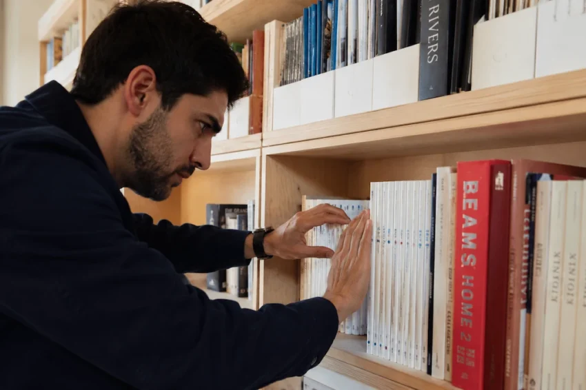 hombre ordenando unos libros meticulosamente.